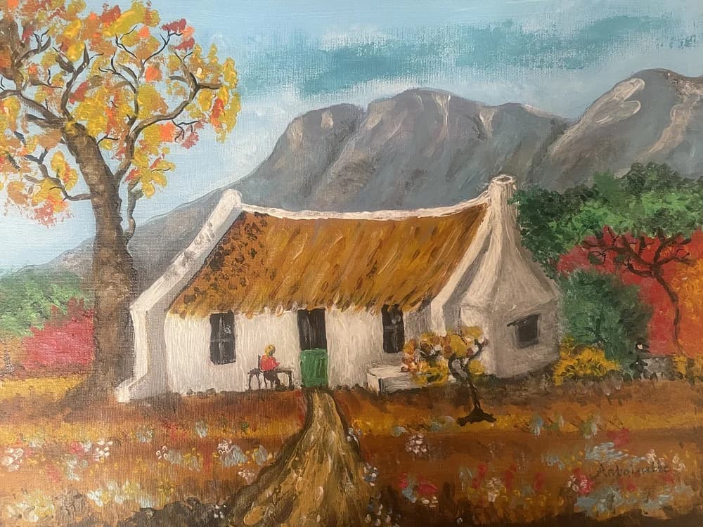 Painting of a white Cape Dutch cottage with thatch roof surrounded by autumn trees and mountains